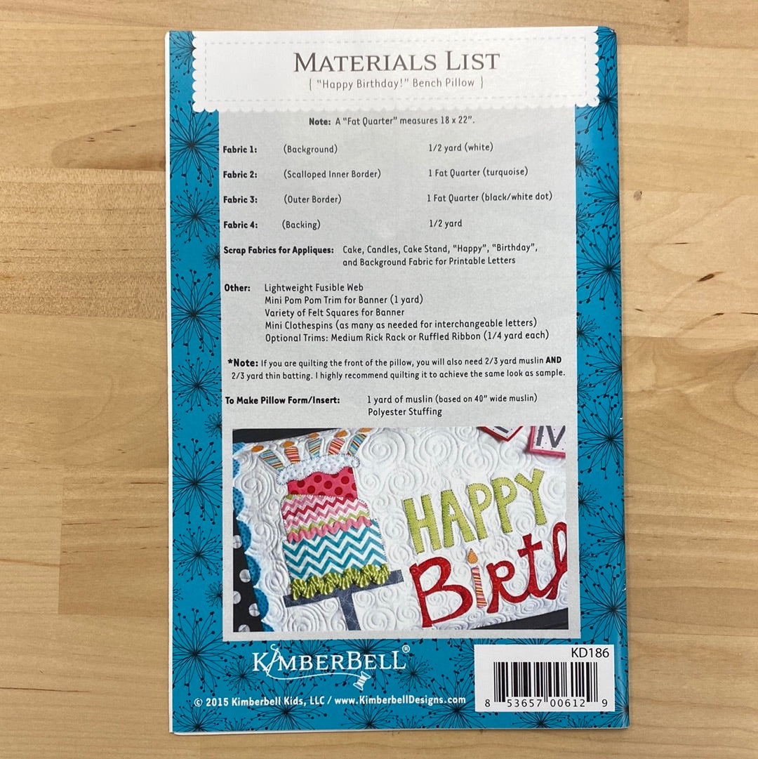 Celebrate in style with our Happy Birthday! Bench Pillow Pattern (KD186) by Kimberbell. This applique design works with a regular sewing machine and features a festive birthday cake on a cake stand complete with candles. The included interchangeable letters allow you to personalize the pillow with a name or sentimental message. Photo shows product back.