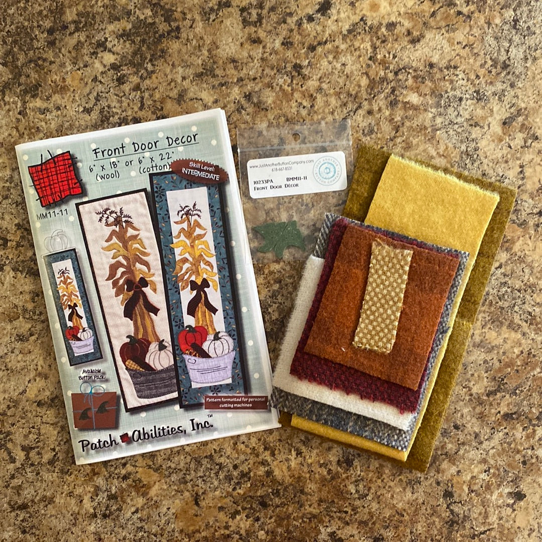 Decorate your front door with ease using our Front Door Decor Pattern with Wool Fabric Kit by Patch Abilities (MM11-11W)! This easy applique pattern features a charming bushel basket design with pumpkins and corn stalks, perfect for the fall season. The included wool kit and buttons make it a simple and fun project for anyone to create a welcoming entrance to their home.