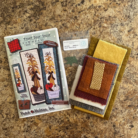 Decorate your front door with ease using our Front Door Decor Pattern with Wool Fabric Kit by Patch Abilities (MM11-11W)! This easy applique pattern features a charming bushel basket design with pumpkins and corn stalks, perfect for the fall season. The included wool kit and buttons make it a simple and fun project for anyone to create a welcoming entrance to their home.