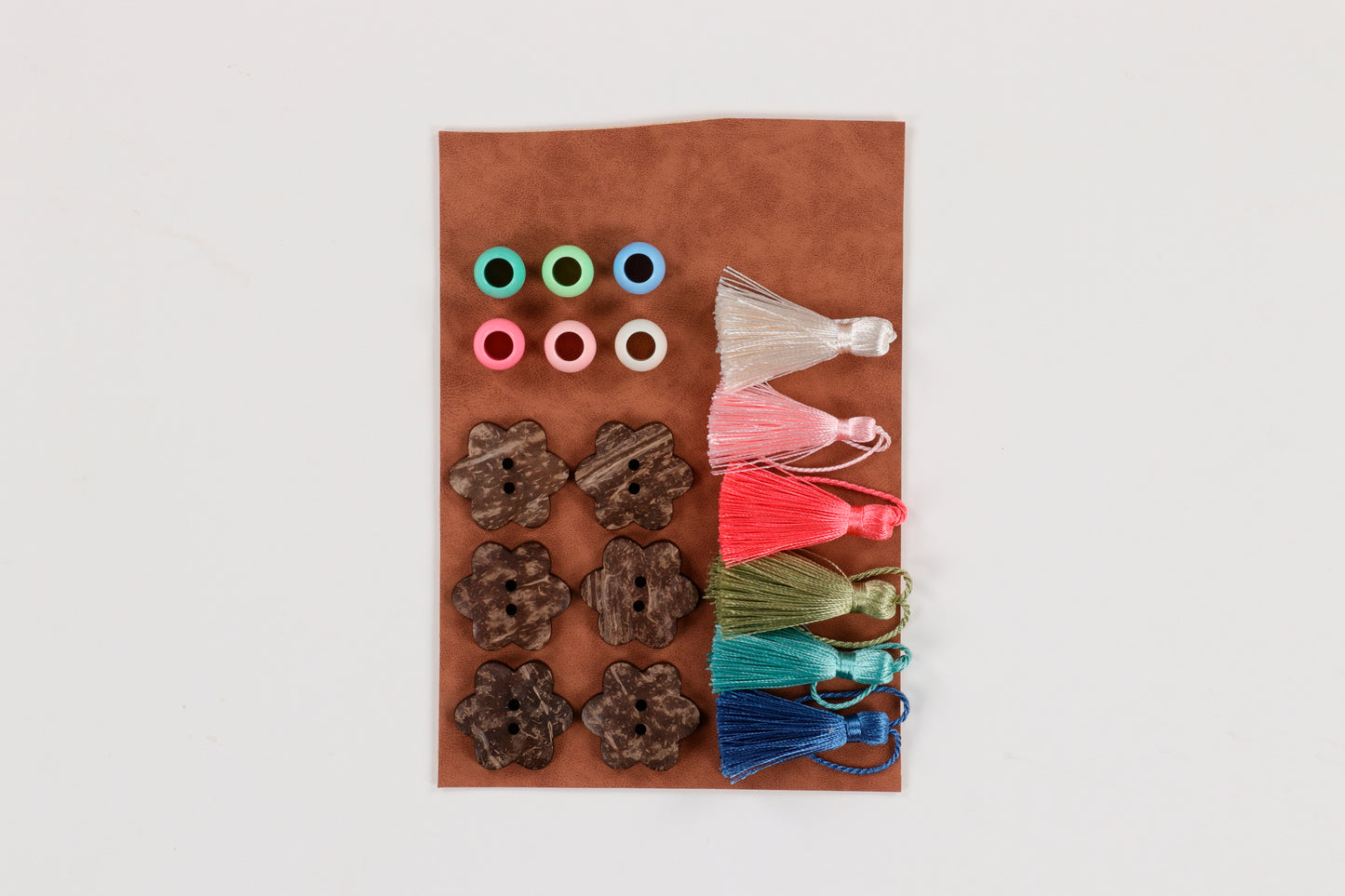 With the Happy Place Embroidery Projects Embellishment Kit (KDKB1292), create stunning gifts and decor with leather, tassels, and beautiful beads! Photo shows the contents of the package.