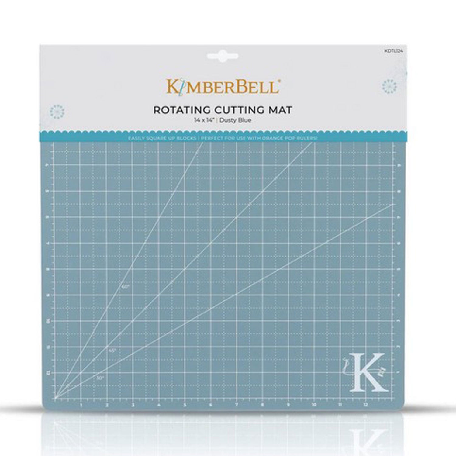The Kimberbell Rotating Cutting Mat measures 13" x 13", and accommodates all sizes of the Orange Pop Ruler. The photo shows the front of the package, with the grid-lines visible on the blue-gray mat with Kimberbell K logo in lower right corner.