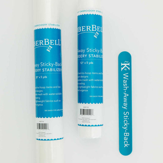 Wash Away Sticky-back stabilizer by Kimberbell is color-coded in blue to reflect it is for use with water to completely dissolve for hard to hoop projects such as chiffon, organza, or other sheer fabrics. Each of the two sizes: 12" x 5 yard and 20” x 5 yard are shown with the color-coordinated slap band. Stitcher’s Joy