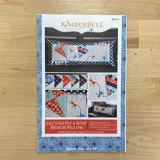 Get ready to soar with the Let's Go Fly A Kite! Bench Pillow Pattern (KD172) by Kimberbell! This playful pattern features a flying geese pieced border and adorable kites with ribbon embellished tails. Photo features the front of the package.