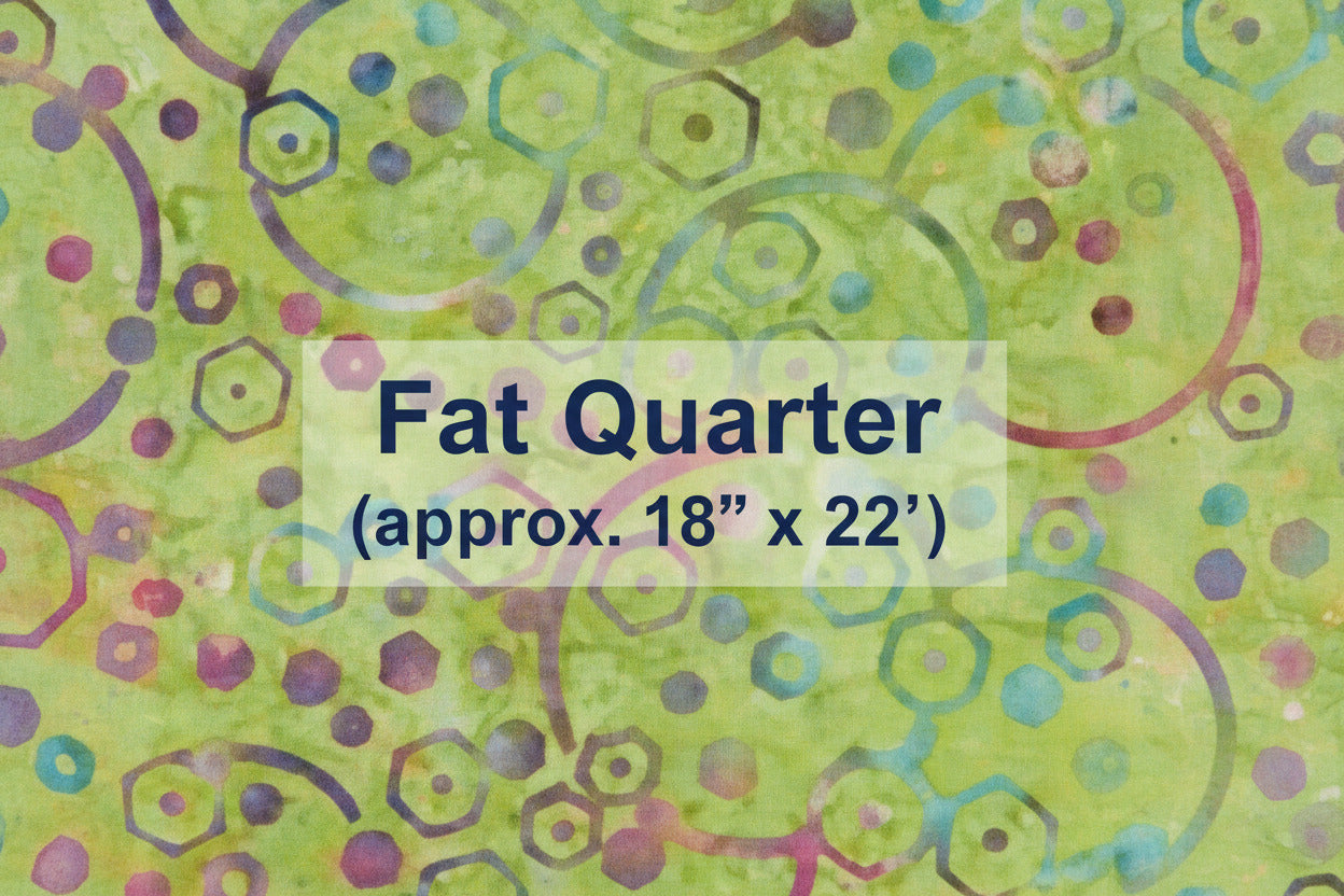 Batik fabric with green background and multicolored circles, hexagons, and dots