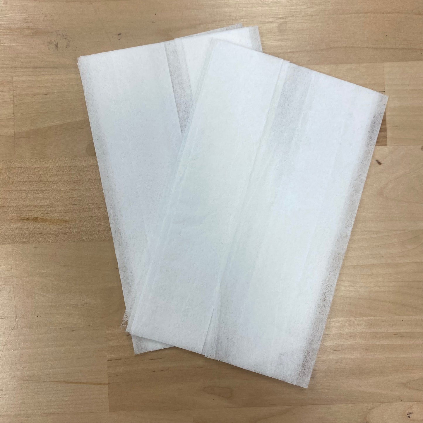 Ten white iron clean sheets on a wooden surface