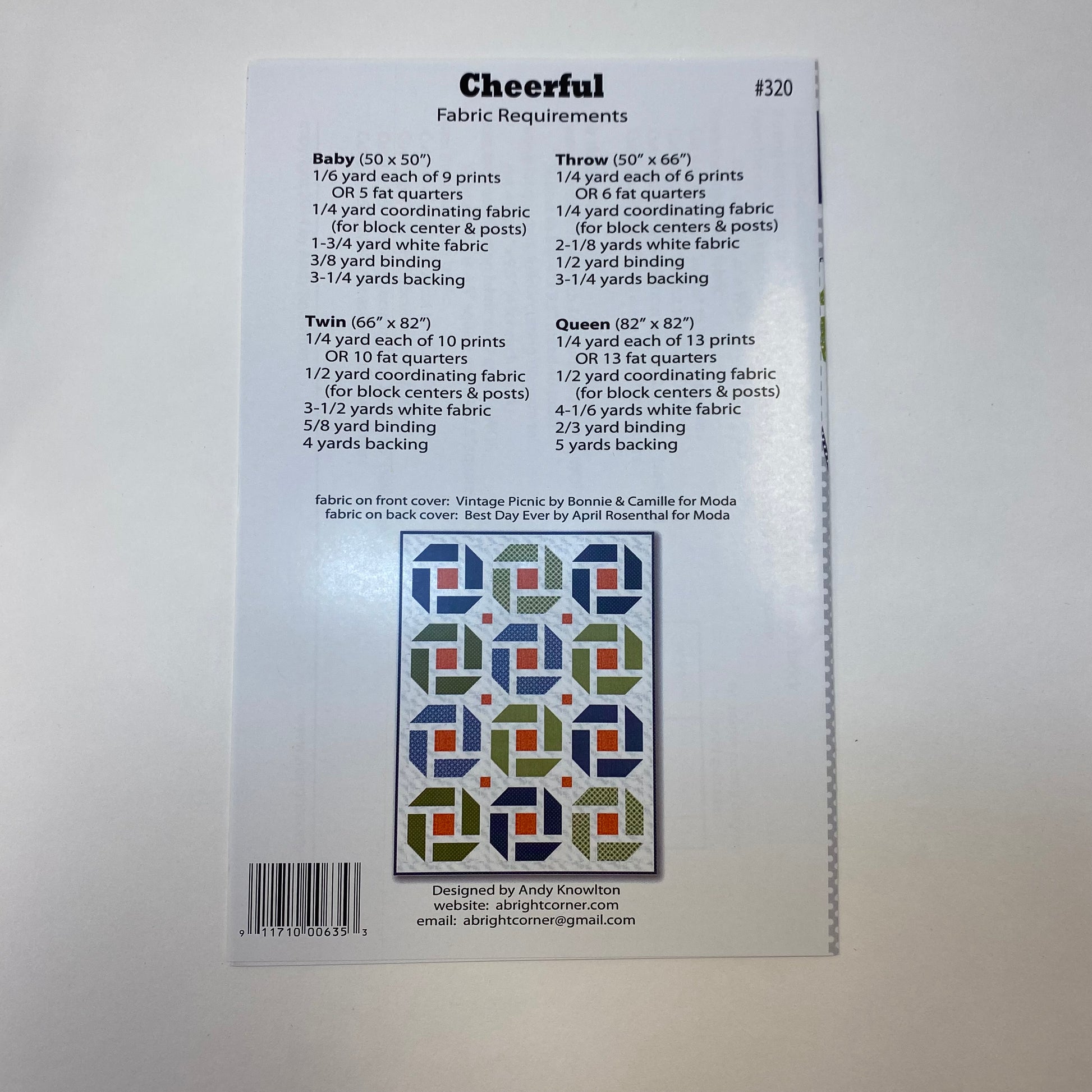 Back of a sewing pattern envelope for 'Cheerful' fabric pattern #320, showing fabric requirements for different quilt sizes, a color sample grid, and a barcode on a white background.