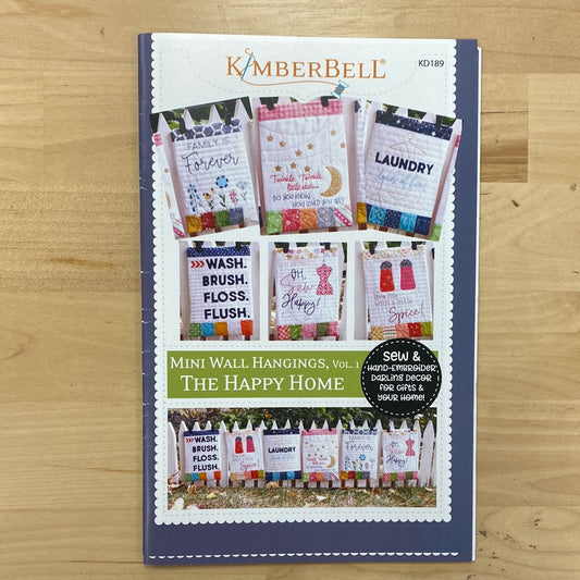 Add some charm to your home decor with our Mini Wall Hangings! These adorable mini quilts are perfect for any room in The Happy Home. Transform your space with a touch of sewing magic. Each wall hanging is made on a regular sewing machine. Photo features product front.
