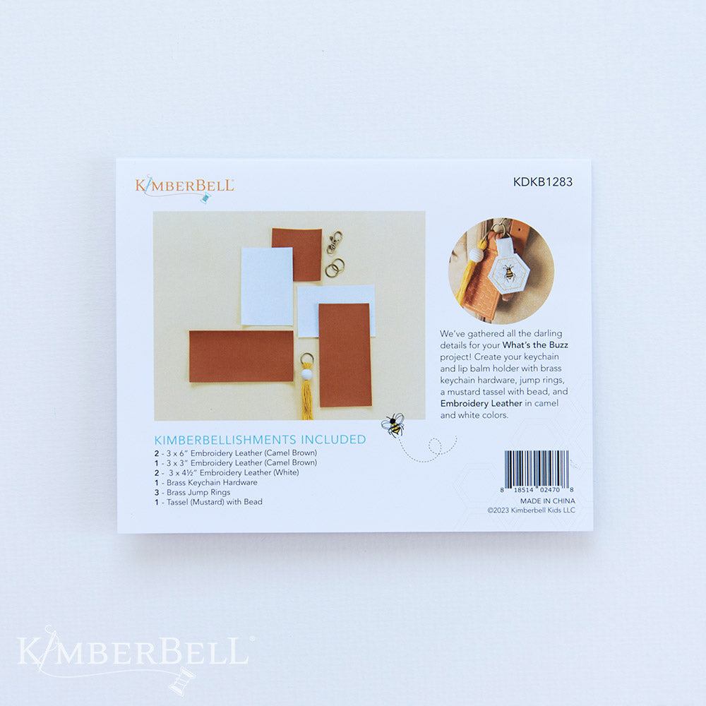 All the darling details for your What’s the Buzz key-chain project in one kit (KDKB1283)! Create your key-chain and lip balm holder with brass key-chain hardware, jump rings, a mustard tassel with bead, and Embroidery Leather in camel and white colors. Photo shows the back of the package.
