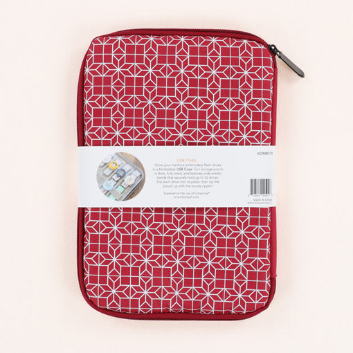 Store your machine embroidery flash drives in a Kimberbell USB Case (KDMR159)! Designed to match Kimberbell's Cranberry Notions Tape Dispenser, the coordinating storage pouch is thick, fully lined, and features wide elastic bands that securely hold up to 32 drives. Photo shows back of backage with quilt block design in white on the cranberry background.