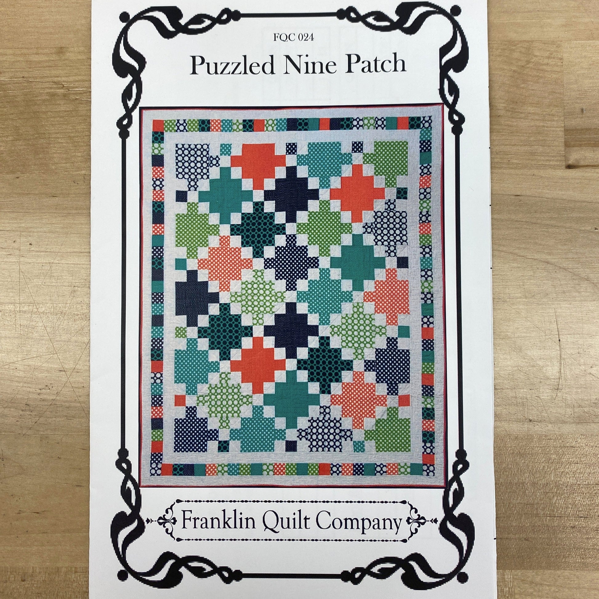 This quilt features alternating monochrome nine-patch blocks with Irish Chain blocks to create a quilt that looks like it is set on-point, bu really only has horizontal seams. it is finished by a simple pieced border, and the pattern includes instructions for multiple sizes. The photo shows the front cover of the pattern with a picture of the finished quilt.