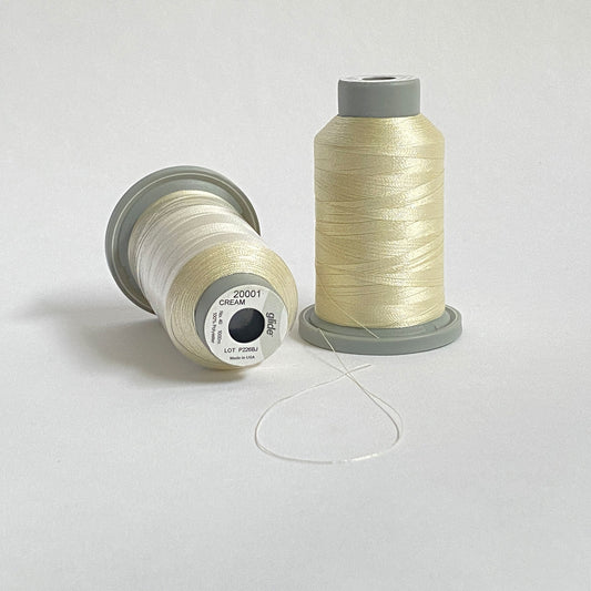 Glide 40 wt. Trilobal polyester thread by Fil-Tec offers superior coverage in each 1,100 yard mini spool. Cream (20001) is a universal off-white that has a slight brown and yellow tinge. Stitcher's Joy