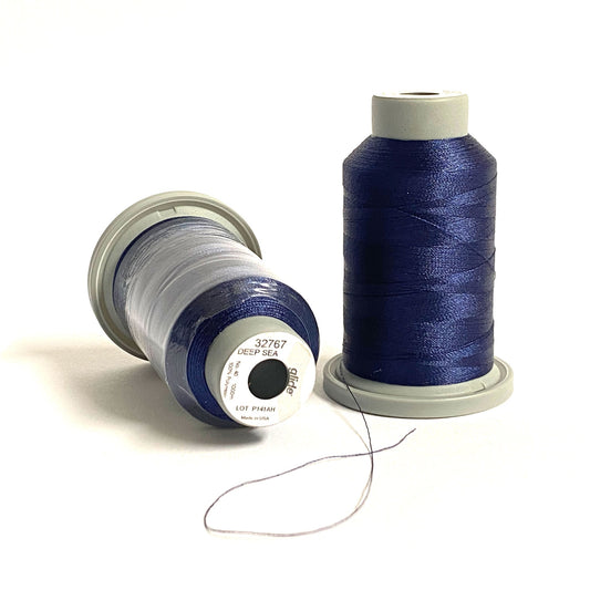 Glide 40 wt. Trilobal Polyester thread by Fil-Tec in Deep Sea (32767) blue is a navy blue with a hint of brightness to contrast with black. This shade of navy is perfect for an nautical theme. Stitcher's Joy