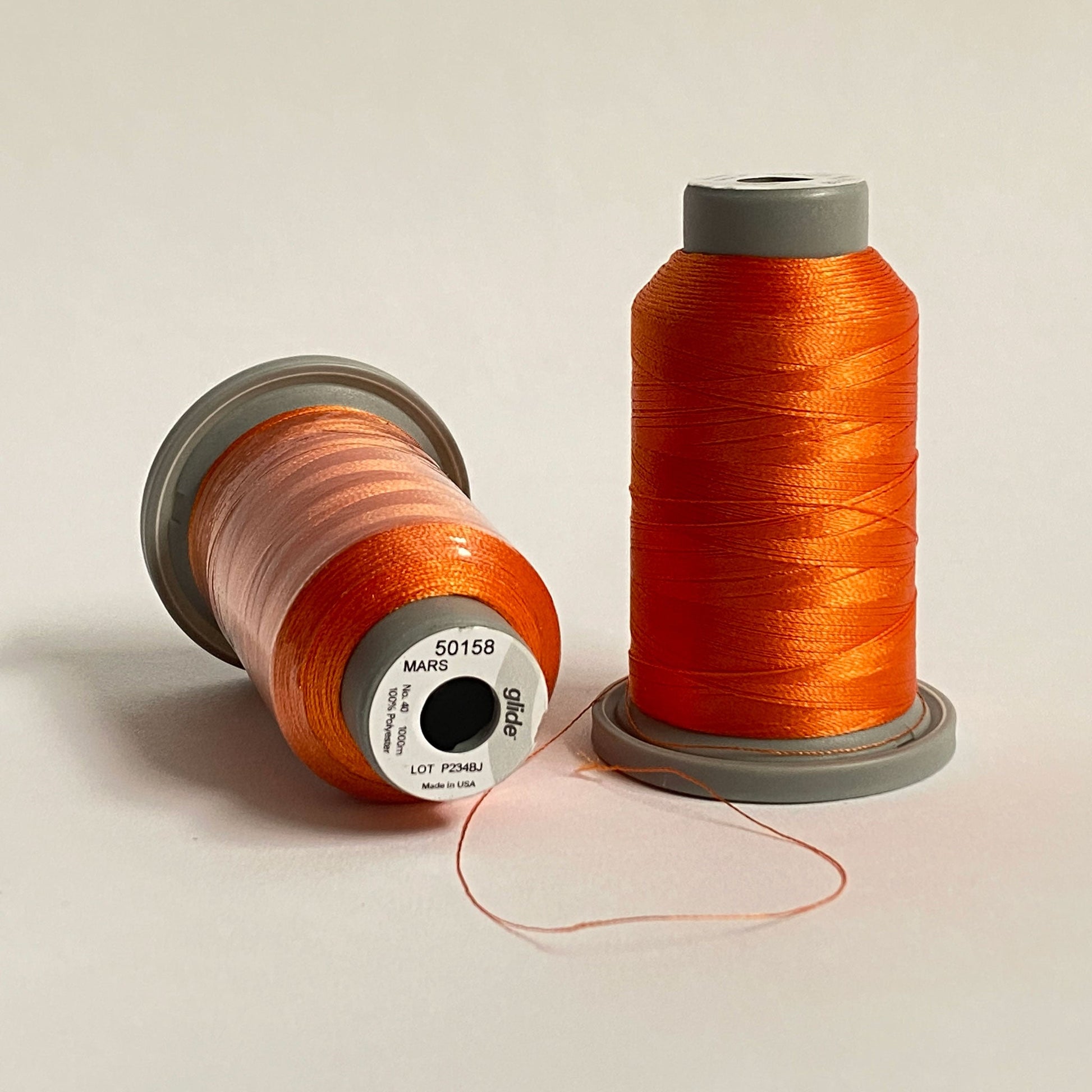 Glide 40 wt Trilobal Polyester thread by Fil-Tec has a slight sheen and excellent coverage, making it the perfect choice for thread-painting and embroidery. The Mars (50158) color is a bright shade of orange, but not flourescent. Stitcher's Joy
