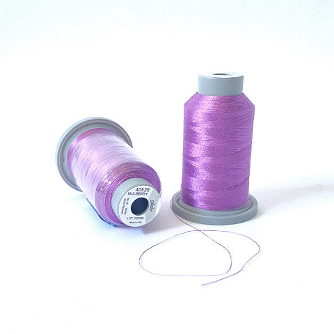 Glide Trilobal Polyester is a 40 weight thread by Fil-tec with a lustrous sheen, exceptional coverage, consistent winding, and impressive strength. It is shown in the 1000m spool size and the color is Mulberry (40528). It is a light to medium purple that is a little more lavender than blue.