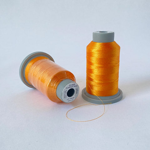 Glide Trilobal Polyester is a 40 weight thread by Fil-tec with a lustrous sheen, exceptional coverage, consistent winding, and impressive strength. The spool shown is a 1000m spool in Pumpkin Seed (51365). It is a medium orange which leans toward the yellow spectrum and captures the transition of gold to orange.