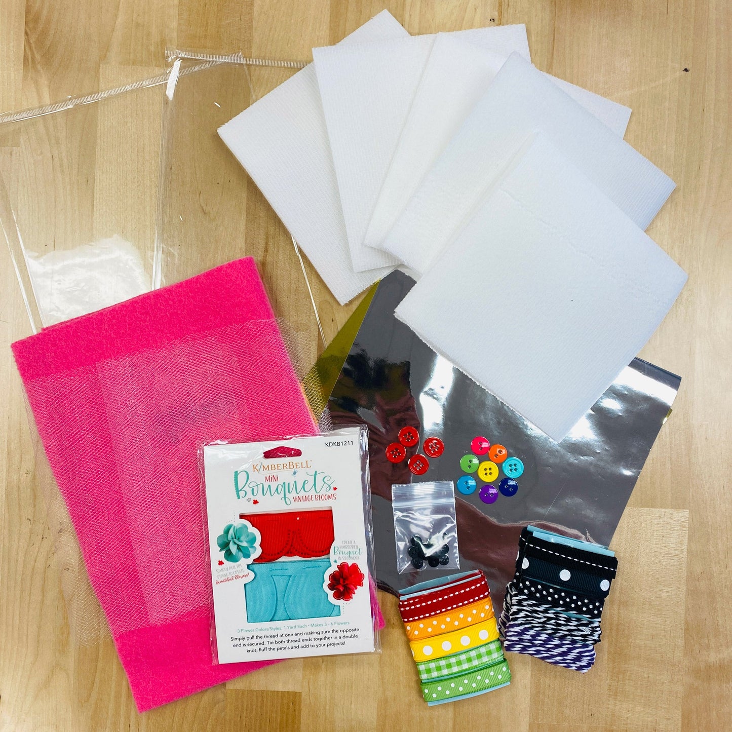All of the fun details needed to complete the Hello Sunshine feature quilt by Kimberbell. The Embellishment Kit includes vinyl, flexi foam, tulle, felt, mylar, pull flowers, buttons, ribbon, and twine.