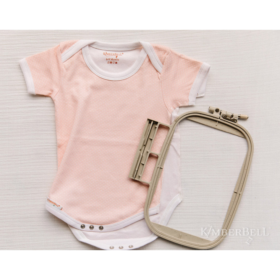Kimberbell Baby Bodysuit shown with open side seam, open snaps and embroidery hoop to show how easy it is to hoop.