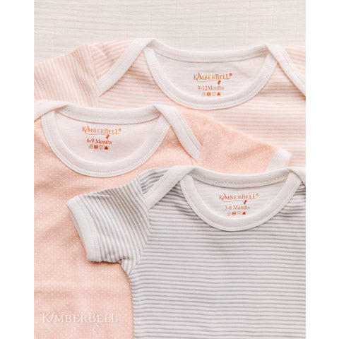 Kimberbell Baby Bodysuits are made with 100% cotton, and are available in 3 sizes of either Blushing Peach or Koala Grey. Photo Shows two peach and one gray bodysuit.