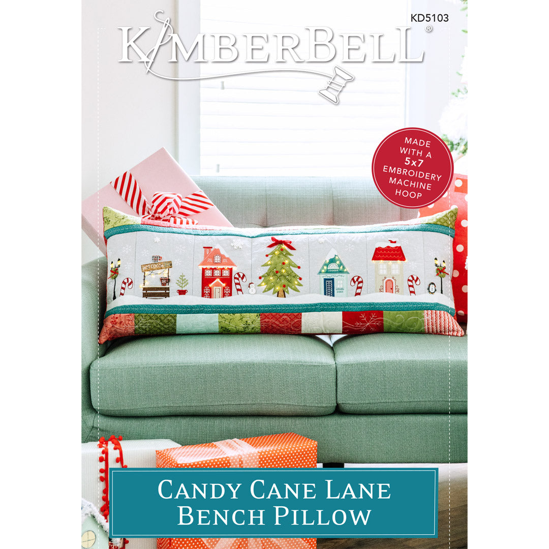 Welcome to Candy Cane Lane! Kimberbell’s whimsical Bench Pillow (KD5103) celebrates the wonder of the holiday season. Lamp posts, houses, a cocoa stand, and a darling tree glow with twinkling Fairy Lights amid drifts of Applique Glitter snow.