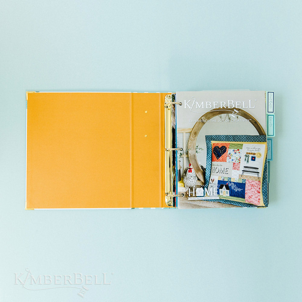Inspire yourself with the Experience the Joy Binder (KDMR131) by Kimberbell.  Each 3" binder includes 5 tab dividers and 2 sheets of stickers, plus gold metal corners to ensure the durability. This photo shows the inside cover, which is solid orange and a few instructions already in the binder.