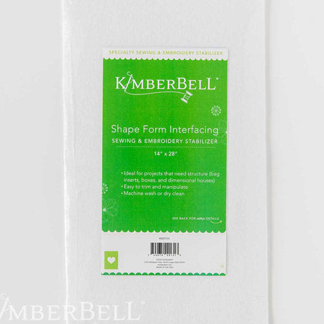 Shape Form Interfacing (KDST131) by Kimberbell is color-coded in green to reflect it is part of Kimberbell’s Specialty Stabilizer line. Both sewists and machine embroiderers can use it to create boxes, hat rims, 3D houses, bag inserts, and more. The picture shows a package which contains one 14” x 18” sheet. Stitcher’s Joy