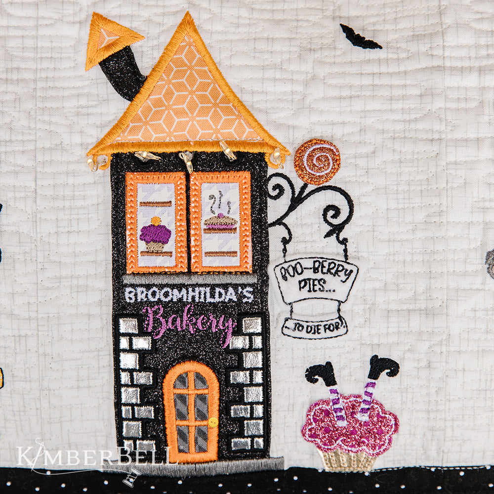 Take a stroll along Twilight Boo-levard (KD594) to visit all of your favorite haunts with this machine embroidery bench pillow pattern by Kimberbell.  With fairy lights, embroidery leather, buttons and mylar and more, the Twilight Boo-levard Bench Pillow is so enchanting, it’s almost scary!